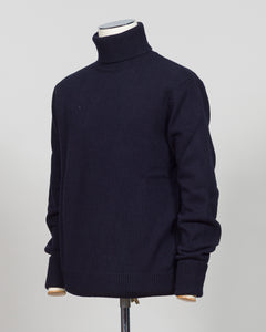 Crafted from premium Italian yarn, the G.R.P. Firenze rollneck knit delivers refined simplicity with architectural precision. The navy tone pairs seamlessly with tailored pieces, while the structured rollneck and clean finish reflect the meticulous construction standards of contemporary menswear. Ideal for layering or worn as a statement piece, this knit bridges casual elegance with wardrobing versatility.