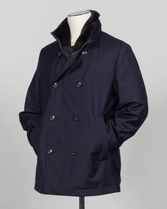 Montecore's double-breasted down jacket combines Italian tailoring precision with practical outerwear design. Navy wool outer with premium down filling delivers warmth without bulk, while structured shoulders and clean lines reflect luxury menswear craftsmanship. Horn buttons and internal quilting detail elevate everyday wear.

Perfect for layering across seasons—wear over knitwear or dress shirts. The relaxed yet refined silhouette suits both smart-casual and dressier occasions. Wind and water-resistant fi