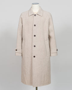 A light beige textured wool coat displayed on a mannequin against a neutral light gray background.