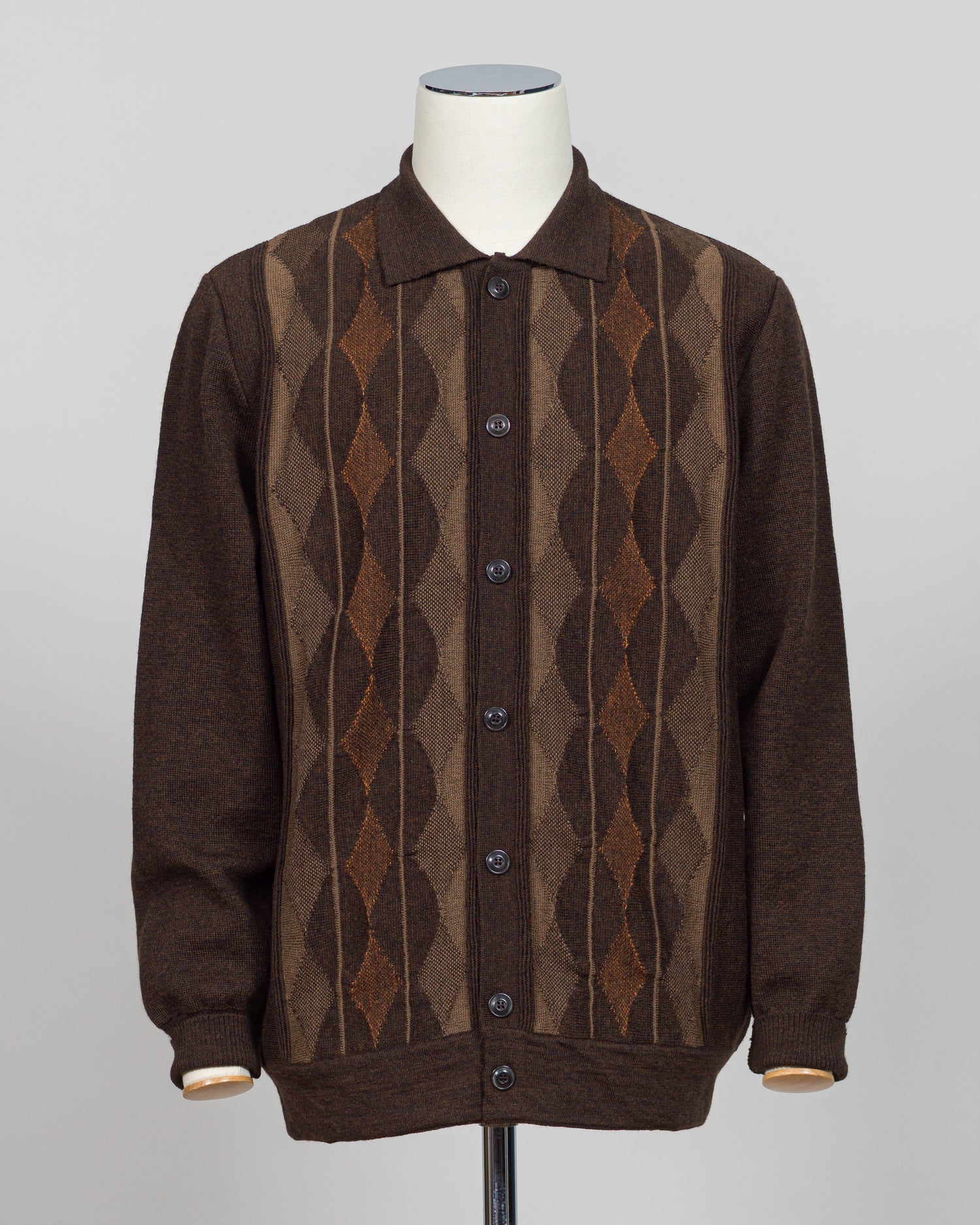 Italian craftsmanship meets timeless design in this G.R.P. Firenze argyle cardigan. The intricate argyle pattern in warm brown tones adds sophisticated visual interest to an elevated everyday piece. Fine knit construction delivers comfort and durability through repeated wear and layering.

Perfect for layering over dress shirts or wearing standalone, this cardigan transitions seamlessly from office to weekend. The classic pattern and neutral colorway pair effortlessly with tailored trousers, jeans, or knitw
