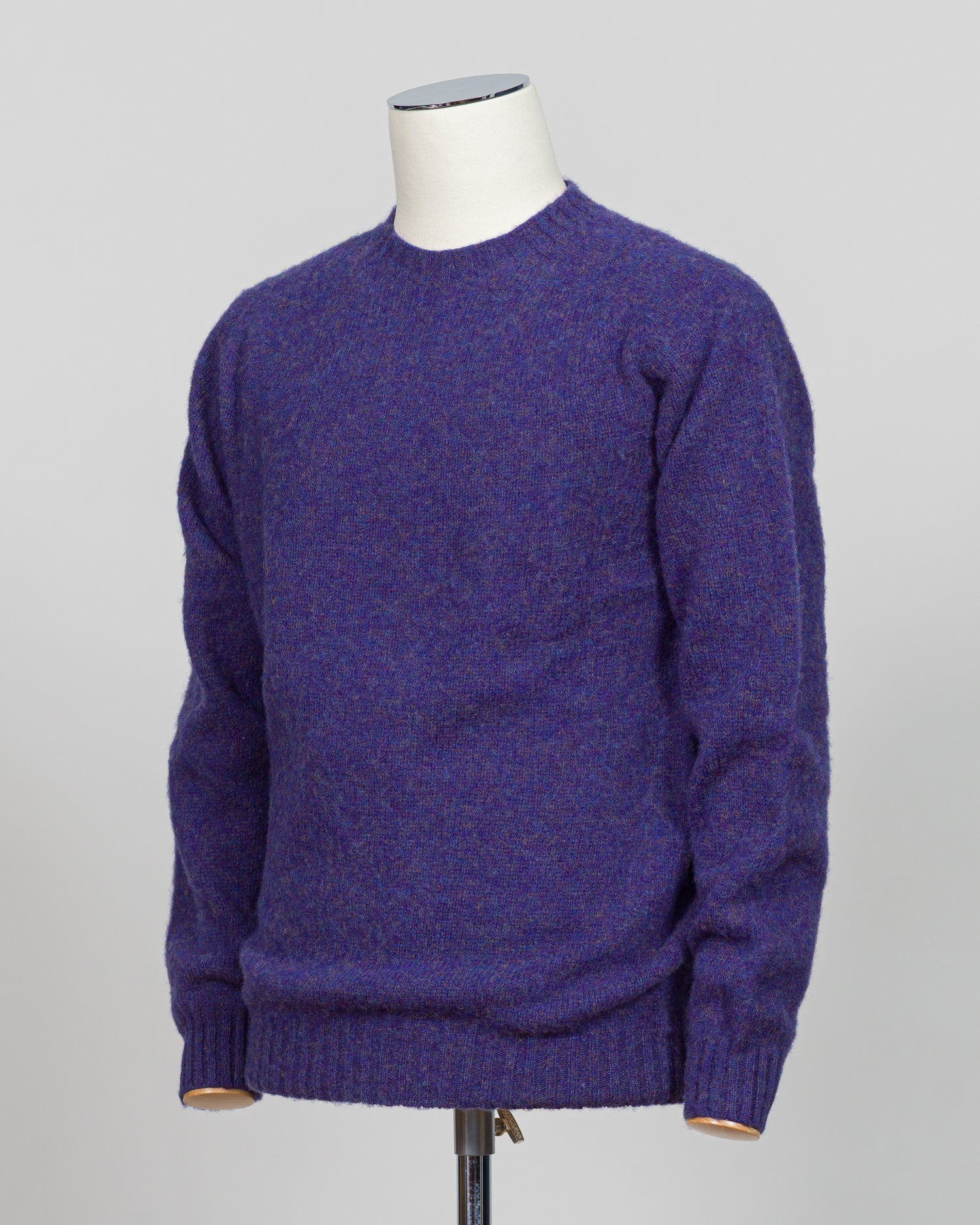Harley of Scotland's iconic shaggy crew neck sweater in iris. Hand-knitted using traditional Scottish techniques, this piece features a distinctive textured surface that catches light beautifully while delivering exceptional softness against the skin. The relaxed crew neck silhouette works seamlessly as a standalone layer or under tailored blazers for refined versatility.

Premium wool construction provides natural warmth and breathability across seasons. The generous shag pile creates visual depth and tact