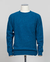 Harley of Scotland's iconic shaggy crew neck sweater in neptune. Hand-knitted using traditional Scottish techniques, this piece features a distinctive textured surface that catches light beautifully while delivering exceptional softness against the skin. The relaxed crew neck silhouette works seamlessly as a standalone layer or under tailored blazers for refined versatility.

Premium wool construction provides natural warmth and breathability across seasons. The generous shag pile creates visual depth and t