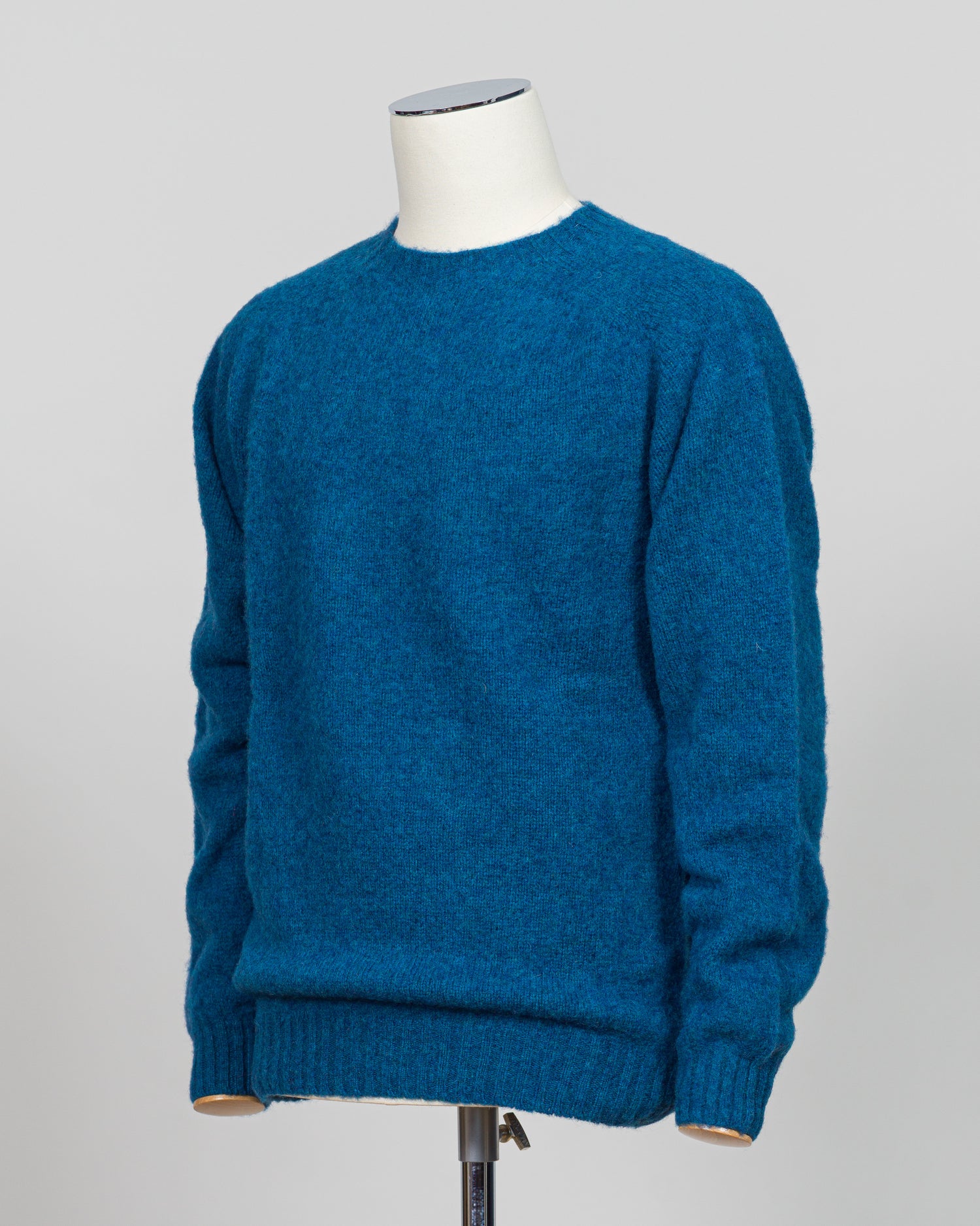 Harley of Scotland's iconic shaggy crew neck sweater in neptune. Hand-knitted using traditional Scottish techniques, this piece features a distinctive textured surface that catches light beautifully while delivering exceptional softness against the skin. The relaxed crew neck silhouette works seamlessly as a standalone layer or under tailored blazers for refined versatility.

Premium wool construction provides natural warmth and breathability across seasons. The generous shag pile creates visual depth and t