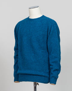 Harley of Scotland's iconic shaggy crew neck sweater in neptune. Hand-knitted using traditional Scottish techniques, this piece features a distinctive textured surface that catches light beautifully while delivering exceptional softness against the skin. The relaxed crew neck silhouette works seamlessly as a standalone layer or under tailored blazers for refined versatility.

Premium wool construction provides natural warmth and breathability across seasons. The generous shag pile creates visual depth and t