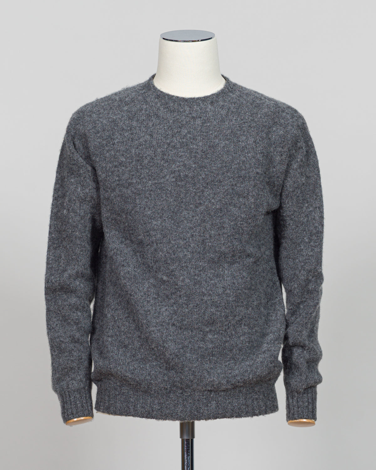 Harley of Scotland's iconic shaggy crew neck sweater in basalt. Hand-knitted using traditional Scottish techniques, this piece features a distinctive textured surface that catches light beautifully while delivering exceptional softness against the skin. The relaxed crew neck silhouette works seamlessly as a standalone layer or under tailored blazers for refined versatility.

Premium wool construction provides natural warmth and breathability across seasons. The generous shag pile creates visual depth and ta
