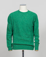 Harley of Scotland's iconic shaggy crew neck sweater in evergreen. Hand-knitted using traditional Scottish techniques, this piece features a distinctive textured surface that catches light beautifully while delivering exceptional softness against the skin. The relaxed crew neck silhouette works seamlessly as a standalone layer or under tailored blazers for refined versatility.

Premium wool construction provides natural warmth and breathability across seasons. The generous shag pile creates visual depth and
