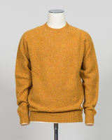 Harley of Scotland's iconic shaggy crew neck sweater in a warm gold dust tone. Hand-knitted using traditional Scottish techniques, this piece features a distinctive textured surface that catches light beautifully while delivering exceptional softness against the skin. The relaxed crew neck silhouette works seamlessly as a standalone layer or under tailored blazers for refined versatility.

Premium wool construction provides natural warmth and breathability across seasons. The generous shag pile creates visu