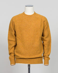 Harley of Scotland's iconic shaggy crew neck sweater in a warm gold dust tone. Hand-knitted using traditional Scottish techniques, this piece features a distinctive textured surface that catches light beautifully while delivering exceptional softness against the skin. The relaxed crew neck silhouette works seamlessly as a standalone layer or under tailored blazers for refined versatility.

Premium wool construction provides natural warmth and breathability across seasons. The generous shag pile creates visu