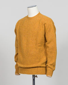 Harley of Scotland's iconic shaggy crew neck sweater in a warm gold dust tone. Hand-knitted using traditional Scottish techniques, this piece features a distinctive textured surface that catches light beautifully while delivering exceptional softness against the skin. The relaxed crew neck silhouette works seamlessly as a standalone layer or under tailored blazers for refined versatility.

Premium wool construction provides natural warmth and breathability across seasons. The generous shag pile creates visu