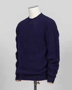 Harley of Scotland's iconic shaggy crew neck sweater in navy. Hand-knitted using traditional Scottish techniques, this piece features a distinctive textured surface that catches light beautifully while delivering exceptional softness against the skin. The relaxed crew neck silhouette works seamlessly as a standalone layer or under tailored blazers for refined versatility.

Premium wool construction provides natural warmth and breathability across seasons. The generous shag pile creates visual depth and tact