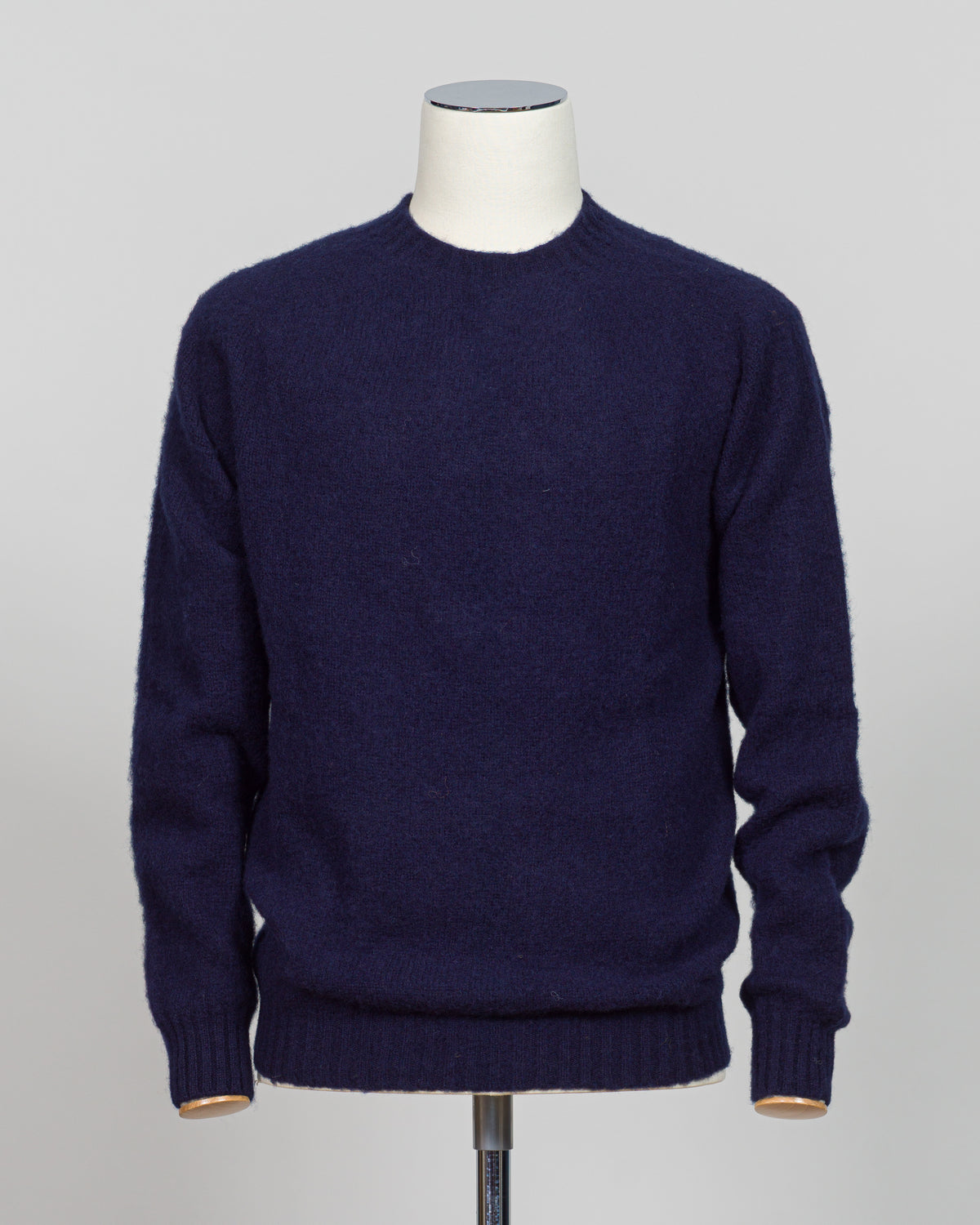 Harley of Scotland's iconic shaggy crew neck sweater in navy. Hand-knitted using traditional Scottish techniques, this piece features a distinctive textured surface that catches light beautifully while delivering exceptional softness against the skin. The relaxed crew neck silhouette works seamlessly as a standalone layer or under tailored blazers for refined versatility.

Premium wool construction provides natural warmth and breathability across seasons. The generous shag pile creates visual depth and tact