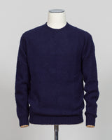 Harley of Scotland's iconic shaggy crew neck sweater in navy. Hand-knitted using traditional Scottish techniques, this piece features a distinctive textured surface that catches light beautifully while delivering exceptional softness against the skin. The relaxed crew neck silhouette works seamlessly as a standalone layer or under tailored blazers for refined versatility.

Premium wool construction provides natural warmth and breathability across seasons. The generous shag pile creates visual depth and tact