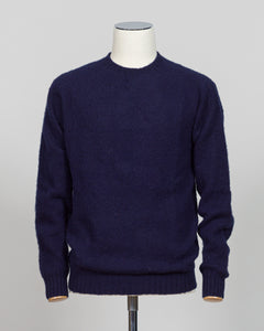 Harley of Scotland's iconic shaggy crew neck sweater in navy. Hand-knitted using traditional Scottish techniques, this piece features a distinctive textured surface that catches light beautifully while delivering exceptional softness against the skin. The relaxed crew neck silhouette works seamlessly as a standalone layer or under tailored blazers for refined versatility.

Premium wool construction provides natural warmth and breathability across seasons. The generous shag pile creates visual depth and tact