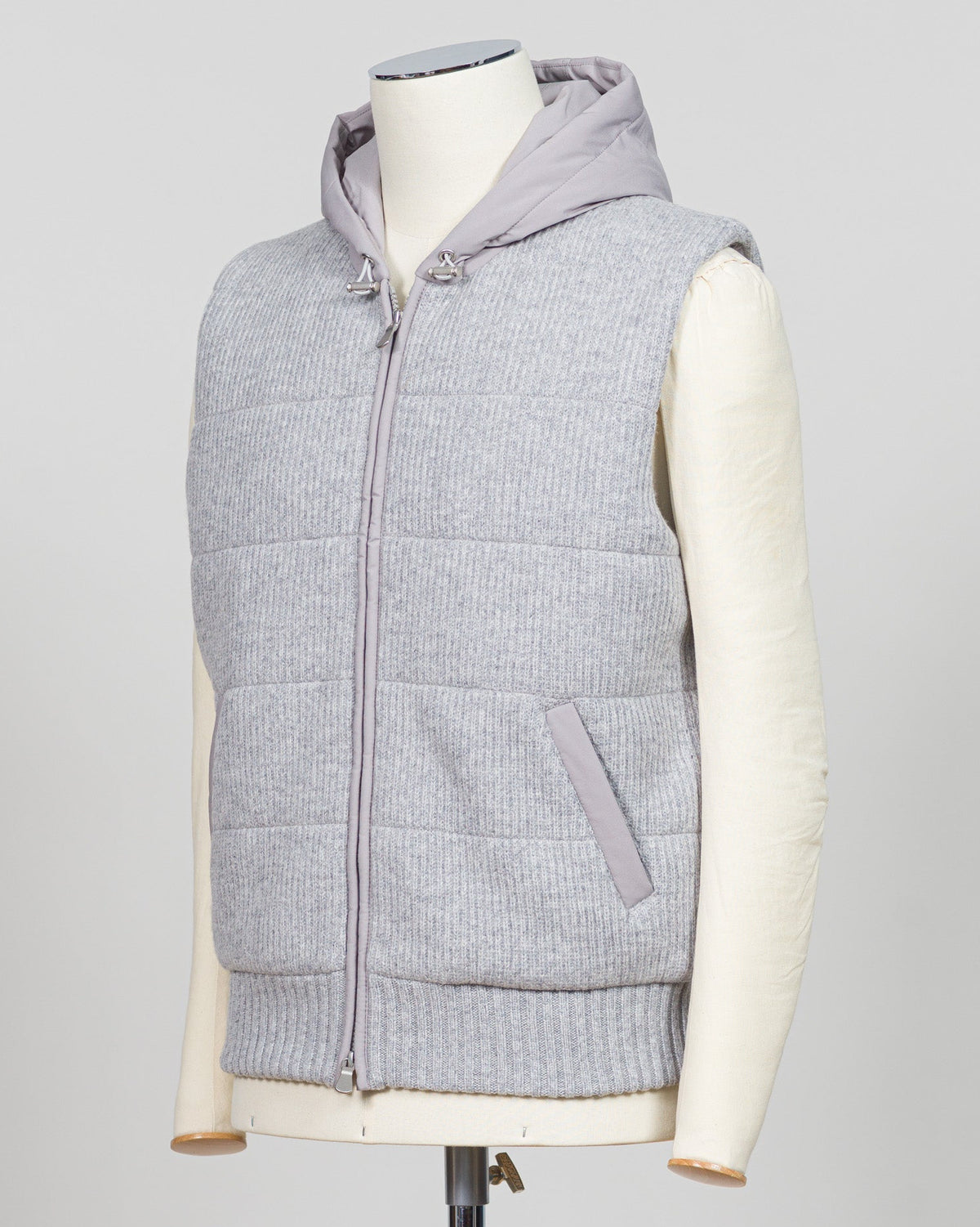 Lightweight insulation meets refined elegance in this Gran Sasso padded hooded vest. The soft light grey colourway pairs seamlessly with layered knitwear or worn solo over shirts for versatile warmth. Italian craftsmanship ensures a tailored silhouette that bridges casual and smart-casual dressing. Essential for the discerning wardrobe. Gran Sasso Padded Hooded Vest / Light Grey