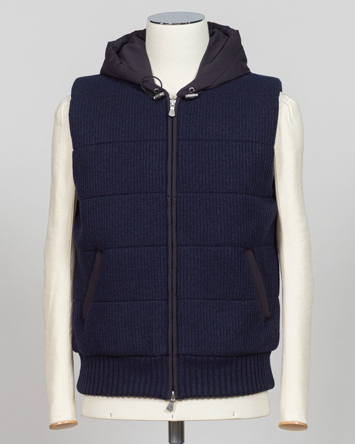 Lightweight padded hooded vest in deep navy. Crafted by Gran Sasso, this essential layer offers sophisticated warmth without bulk. Perfect layered over knitwear or worn standalone for refined, modern styling. Premium construction ensures lasting comfort and durability. Gran Sasso Padded Hooded Vest / Navy