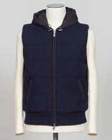 Lightweight padded hooded vest in deep navy. Crafted by Gran Sasso, this essential layer offers sophisticated warmth without bulk. Perfect layered over knitwear or worn standalone for refined, modern styling. Premium construction ensures lasting comfort and durability. Gran Sasso Padded Hooded Vest / Navy