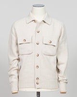 An off-white knit cardigan sweater with brown buttons, displayed on a cream-colored mannequin against a light gray background.