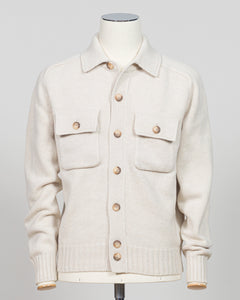 An off-white knit cardigan sweater with brown buttons, displayed on a cream-colored mannequin against a light gray background.