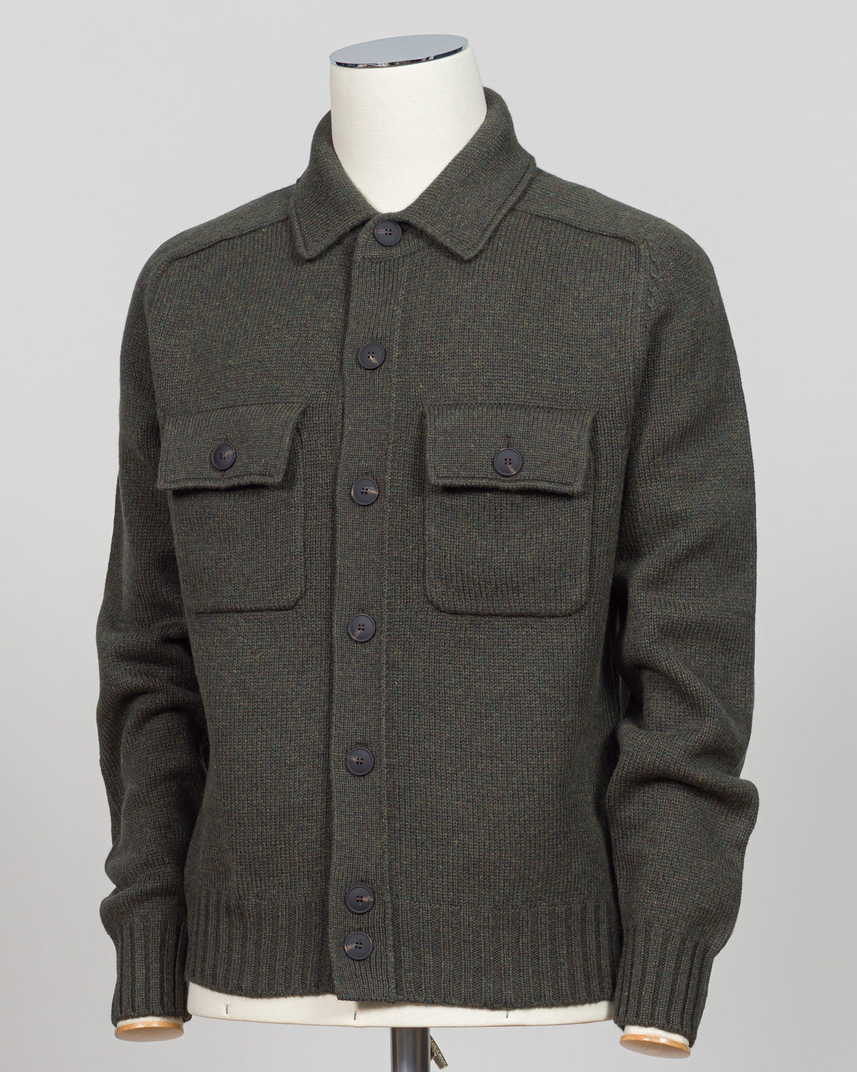 A dark green knit cardigan jacket displayed on a white mannequin torso against a light gray background.
