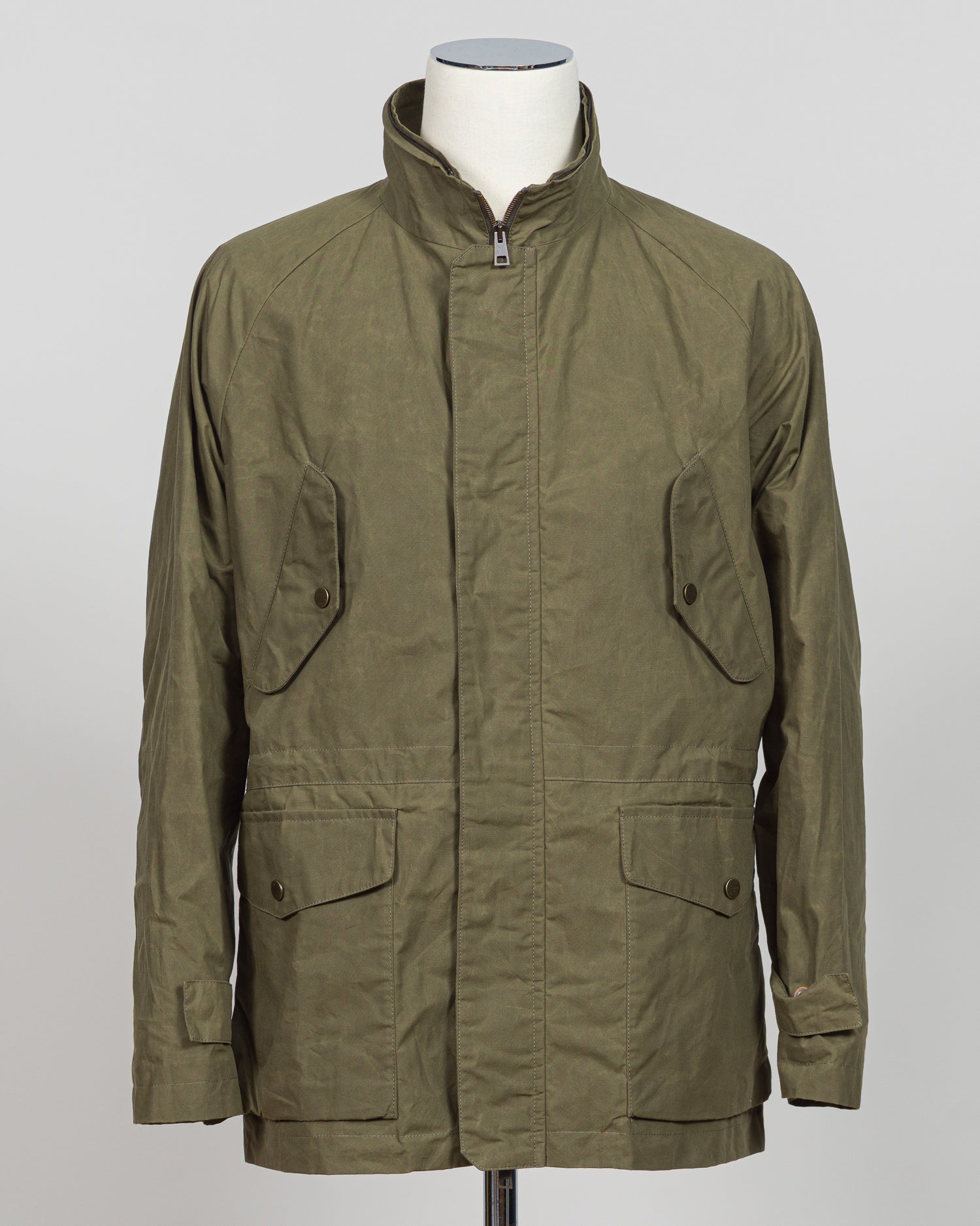 A timeless waxed cotton short parka built for versatile layering and unpredictable weather. The water-resistant finish and structured silhouette offer refined protection without bulk, while the compact length ensures easy movement and pairs seamlessly with tailored pieces. Durable construction and a refined aesthetic make it a wardrobe essential for the discerning gentleman.