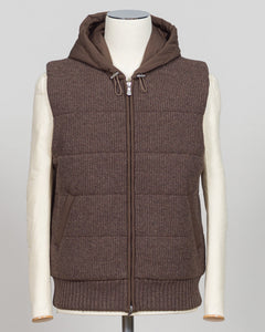 Lightweight padded hooded vest in rich brown, crafted by Italian luxury knitwear specialist Gran Sasso. Designed for layering over fine knits and tailored pieces, this vest offers warmth without bulk. The structured silhouette and refined proportions suit both casual and smart-casual styling. Perfect for transitional seasons and travel. Gran Sasso Padded Hooded Vest / Brown