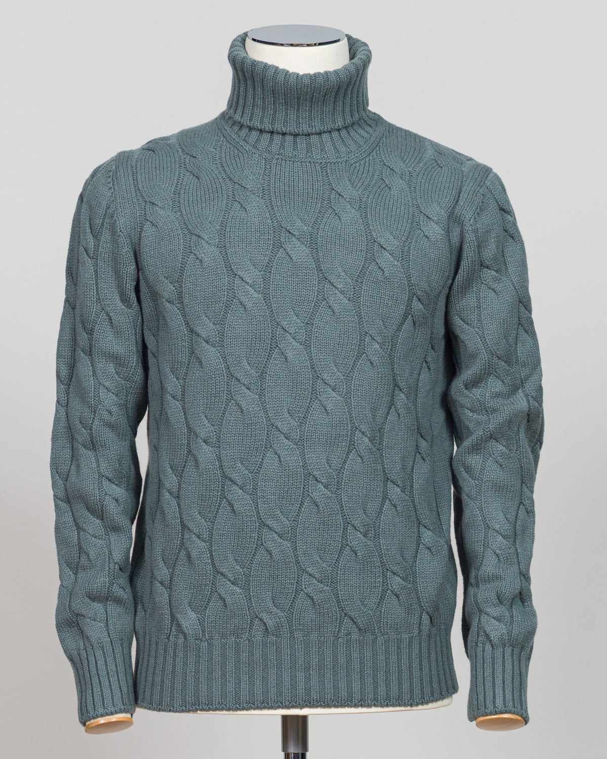 A refined cable-knit roll neck in soft sage green. Crafted with classic construction and versatile color, it pairs effortlessly with tailored trousers or layered beneath a suit jacket. Essential luxury knitwear for the discerning wardrobe. Gran Sasso Cable Roll Neck Knit / Sage Green