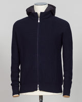 A dark navy blue ribbed knit zip-up hoodie with a hood, displayed on a mannequin torso against a light gray background. Water-repellent merino wool hoodie in navy. Engineered for layering and everyday wear, this Gran Sasso piece combines breathable warmth with practical weather resistance. Perfect for transitional seasons and active lifestyles. Gran Sasso Rain Wool Hoodie / Navy