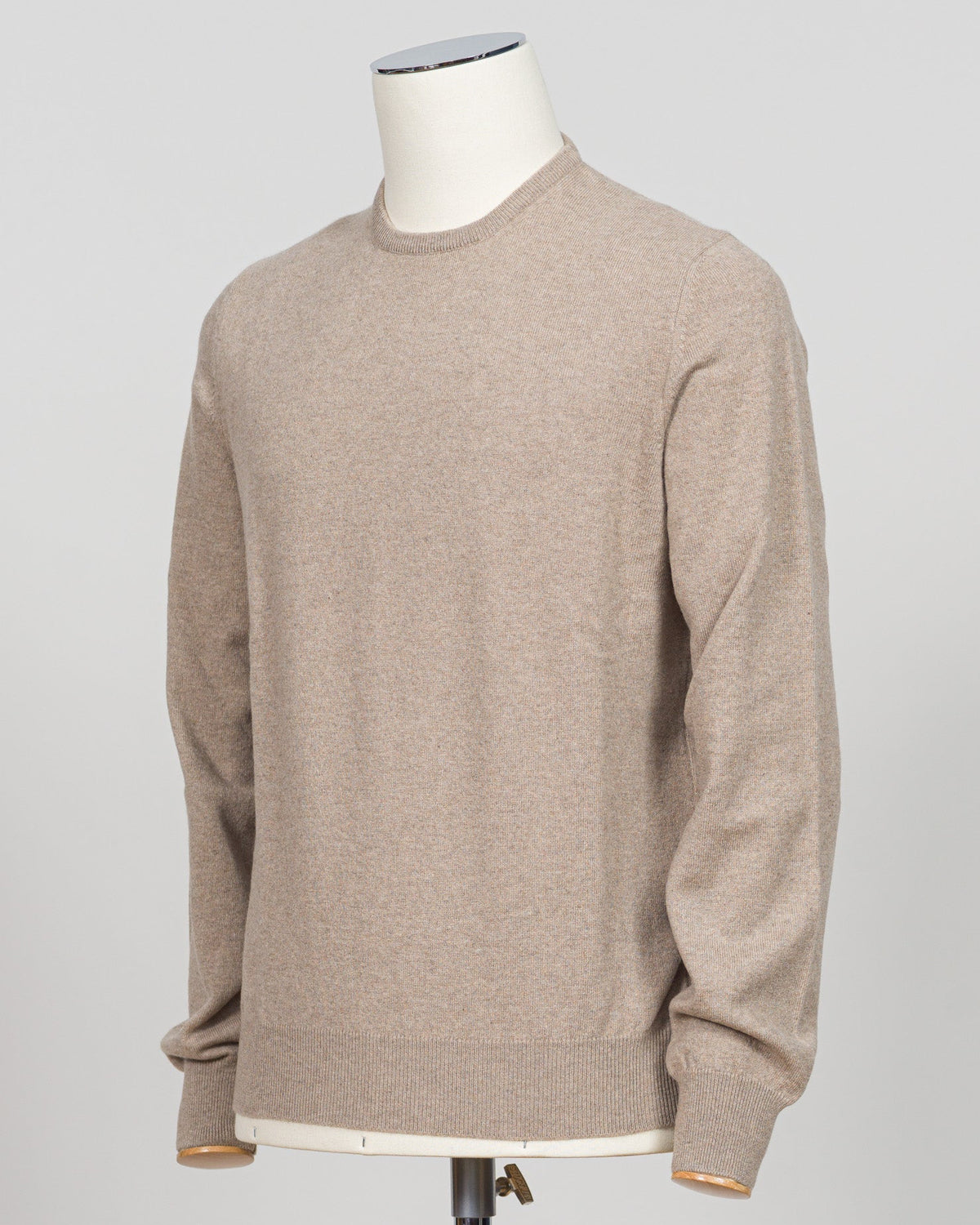 A light beige crewneck sweater displayed on a white mannequin torso against a neutral light gray background.  Gran Sasso's timeless cashmere crew neck in soft beige epitomizes understated luxury. Crafted from 100% pure cashmere with a vintage-washed finish that develops character with wear, this Italian-made essential features a relaxed fashion fit, ribbed detailing at the hem and cuffs, and a refined crew neckline. An investment piece that anchors any wardrobe. Gran Sasso Cashmere Crew Neck / Beige