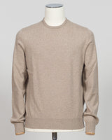 A light beige crewneck knit sweater displayed on a white mannequin torso against a neutral light gray background.  Gran Sasso's timeless cashmere crew neck in soft beige epitomizes understated luxury. Crafted from 100% pure cashmere with a vintage-washed finish that develops character with wear, this Italian-made essential features a relaxed fashion fit, ribbed detailing at the hem and cuffs, and a refined crew neckline. An investment piece that anchors any wardrobe. Gran Sasso Cashmere Crew Neck / Beige