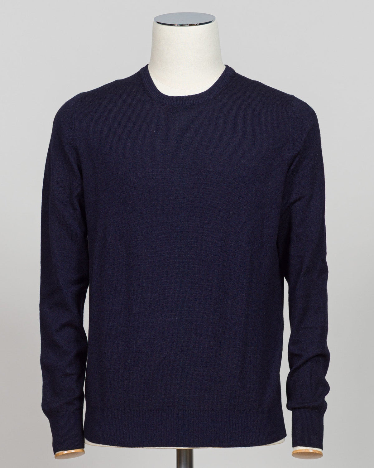 A dark navy blue long-sleeve crewneck sweater displayed on a white mannequin torso against a light gray background.  Sophisticated navy cashmere crew neck from Gran Sasso, crafted from 100% pure cashmere for exceptional softness and warmth. The timeless crew silhouette offers versatile styling—equally at home layered under a blazer or worn as a refined casual piece. Made in Italy with meticulous attention to detail. A foundational luxury knitwear essential for the discerning wardrobe. Gran Sasso Cashmere Cr