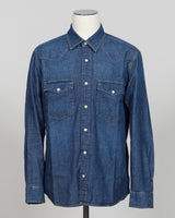 Crafted from premium Tela Genova fabric, this Western shirt delivers understated sophistication in a faded blue that transitions beautifully across seasons. The structured weave and refined tailoring define clean lines, while pearl snaps and a relaxed collar offer versatile styling—equally at home layered under a blazer or worn open as a lightweight layer. Perfect for the discerning dresser who values quality construction and timeless design.