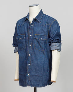 Crafted from premium Tela Genova fabric, this Western shirt delivers understated sophistication in a faded blue that transitions beautifully across seasons. The structured weave and refined tailoring define clean lines, while pearl snaps and a relaxed collar offer versatile styling—equally at home layered under a blazer or worn open as a lightweight layer. Perfect for the discerning dresser who values quality construction and timeless design.