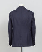 Modello: Sorrento
Hand finished 
Unconstructed 
Half lined
Composition: 100% Virgin Wool Flannel
Tone on tone herringbone 
Article: G20953
Col 1022 / Navy
Made in Napoli, Italy