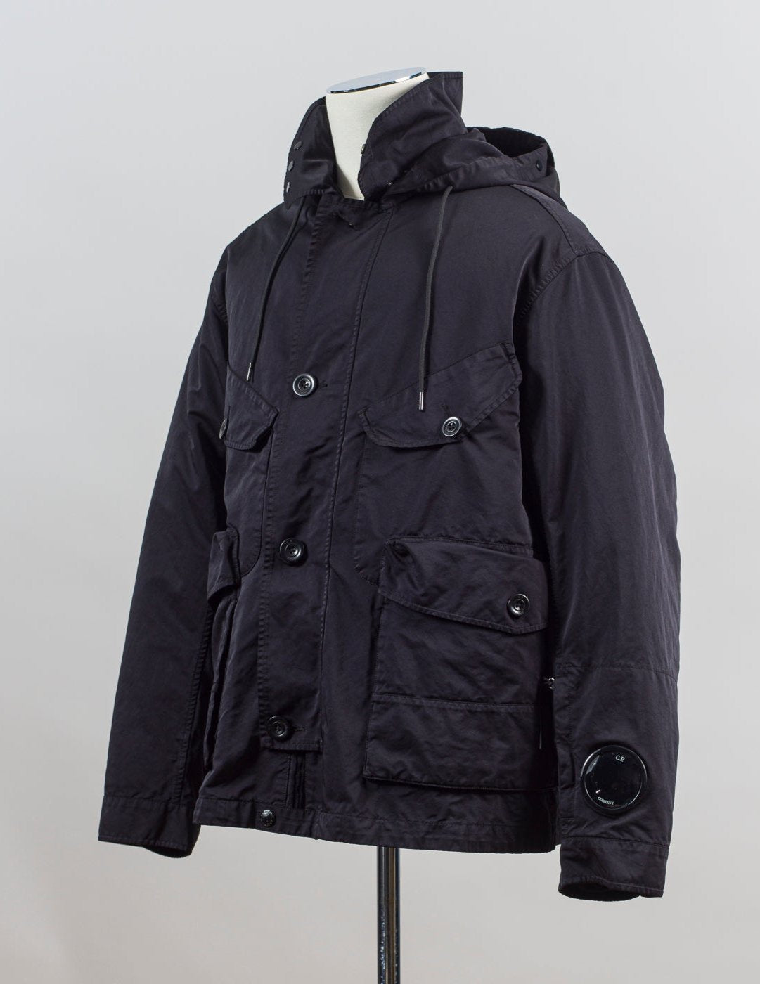 External fabric: 66% Polyester 34% Polyamide
Lens detail on left sleeve

Real Corozo buttons
Article: 17CMOW224A 110089G
Color: Black / 999
Detachable down layer
External Fabric: 100% Polyamide
Lining: 100% Polyamide
Filling: 90% Grey duck down 10% feather C.P Company Micro Kei La Mille Jacket / Black