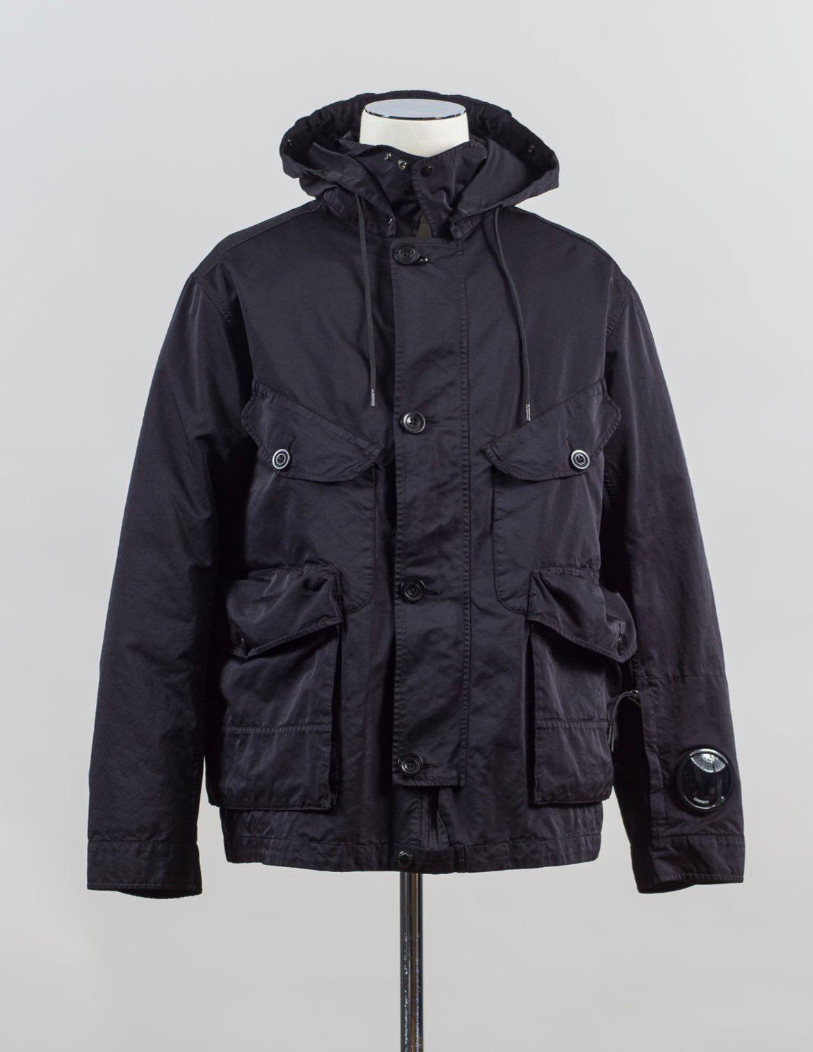 External fabric: 66% Polyester 34% Polyamide
Lens detail on left sleeve

Real Corozo buttons
Article: 17CMOW224A 110089G
Color: Black / 999
Detachable down layer
External Fabric: 100% Polyamide
Lining: 100% Polyamide
Filling: 90% Grey duck down 10% feather C.P Company Micro Kei La Mille Jacket / Black