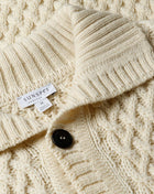 Knitted with a chunky, open cable stitch, this merino wool cardigan jacket is a contemporary take on a traditional Sunspel classic. Made in England, it has a funnel neck collar and horn buttons. Warm, and comfortable it is the ideal transeasonal outer layer. Made in England 100% Merino Wool Cool hand wash Do not tumble dry Dry cleanable Sunspel Cable Knit Cardigan Jacket / Ecru