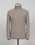 Gran Sasso cable knit roll neck made of special 3-ply Air Wool quality. The special feature of this garment is the yarn that holds microscopic air bubbles between the fibers, making it at the same time warm and light.  Art. 13117/22622 Col. 030 Light Sand 100% Wool Made in Italy  