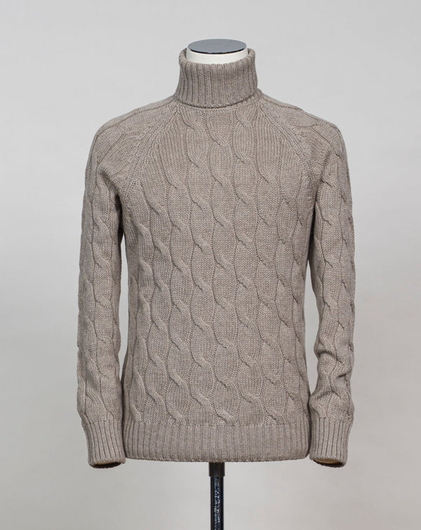 Gran Sasso cable knit roll neck made of special 3-ply Air Wool quality. The special feature of this garment is the yarn that holds microscopic air bubbles between the fibers, making it at the same time warm and light.  Art. 13117/22622 Col. 030 Light Sand 100% Wool Made in Italy  