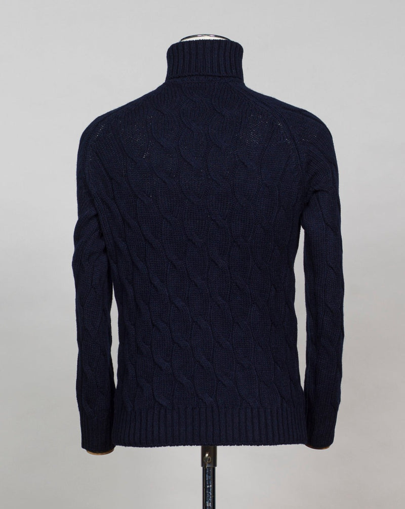 Gran Sasso cable knit roll neck made of special 3-ply Air Wool quality. The special feature of this garment is the yarn that holds microscopic air bubbles between the fibers, making it at the same time warm and light.  Art. 13117/22622 Col. 598 Navy 100% Wool Made in Italy