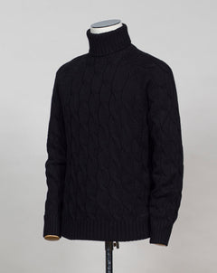 Gran Sasso cable knit roll neck made of special 3-ply Air Wool quality. The special feature of this garment is the yarn that holds microscopic air bubbles between the fibers, making it at the same time warm and light.  Art. 13117/22622 Col. 099 Black 100% Wool Made in Italy 