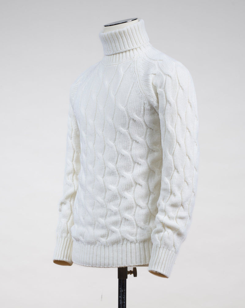 Gran Sasso cable knit roll neck made of special 3-ply Air Wool quality. The special feature of this garment is the yarn that holds microscopic air bubbles between the fibers, making it at the same time warm and light.  Art. 13117/22622 Col. 005 Off White 100% Wool Made in Italy Gran Sasso Air Wool Cable Roll Neck / Off White