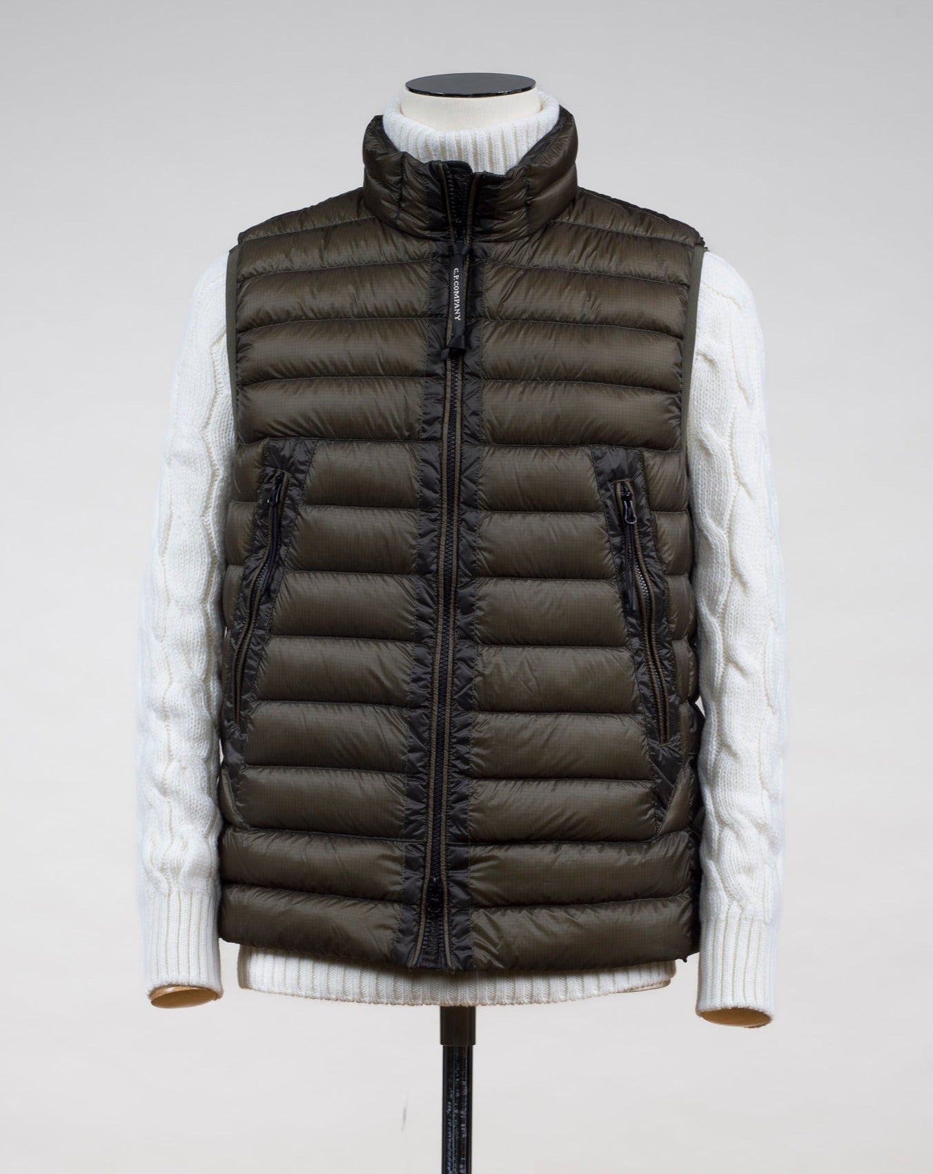Down filled bodywarmer 95% down 5% feather Two zipped hand warming pockets in front Adjustable hem Two way zip in front 15CMOW0171A 006099A Col 670 D. Green / Olive Night C.P. Company DD Shell Down Vest / Olive Night