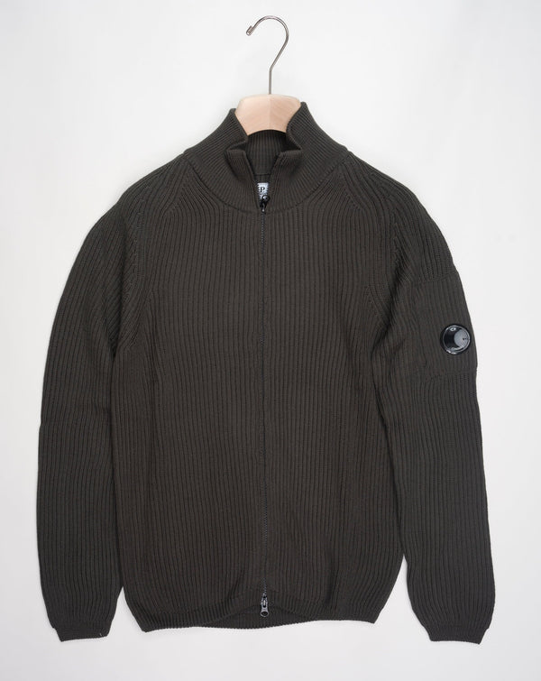 Art. 15CMKN228A 006595A Col. 670 Olive Night / Green Full two way zip C.P. Company lens detail on left sleeve Heavy ribbed  Composition: 55% wool 45% pl C.P. Company Re-Wool Zipped Knit / Olive Night