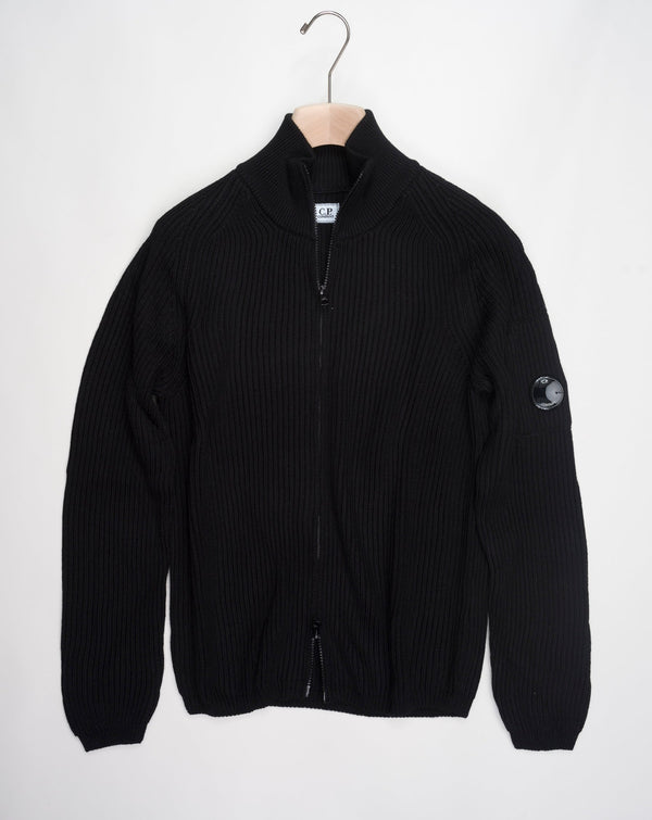 Art. 15CMKN228A 006595A Col. 999 Black Full two way zip C.P. Company lens detail on left sleeve Heavy ribbed  Composition: 55% wool 45% pl C.P. Company Re-Wool Zipped Knit / Black