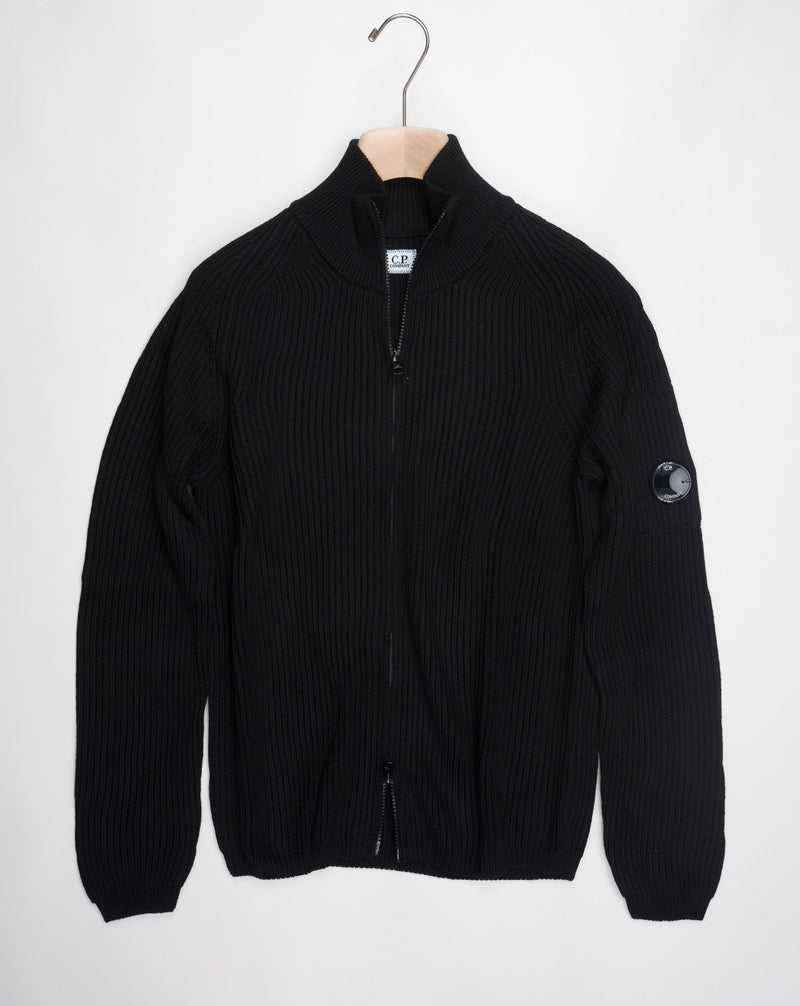 Art. 15CMKN228A 006595A Col. 999 Black Full two way zip C.P. Company lens detail on left sleeve Heavy ribbed  Composition: 55% wool 45% pl C.P. Company Re-Wool Zipped Knit / Black
