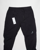Multifilament fabric in Recycled nylon yarn Regular fit Drawstring waist Cuffed leg opening Single cargo pocket on left Leg Lens detail Garment dyed Article: 15CMPA247A005904G Color: Black / 999