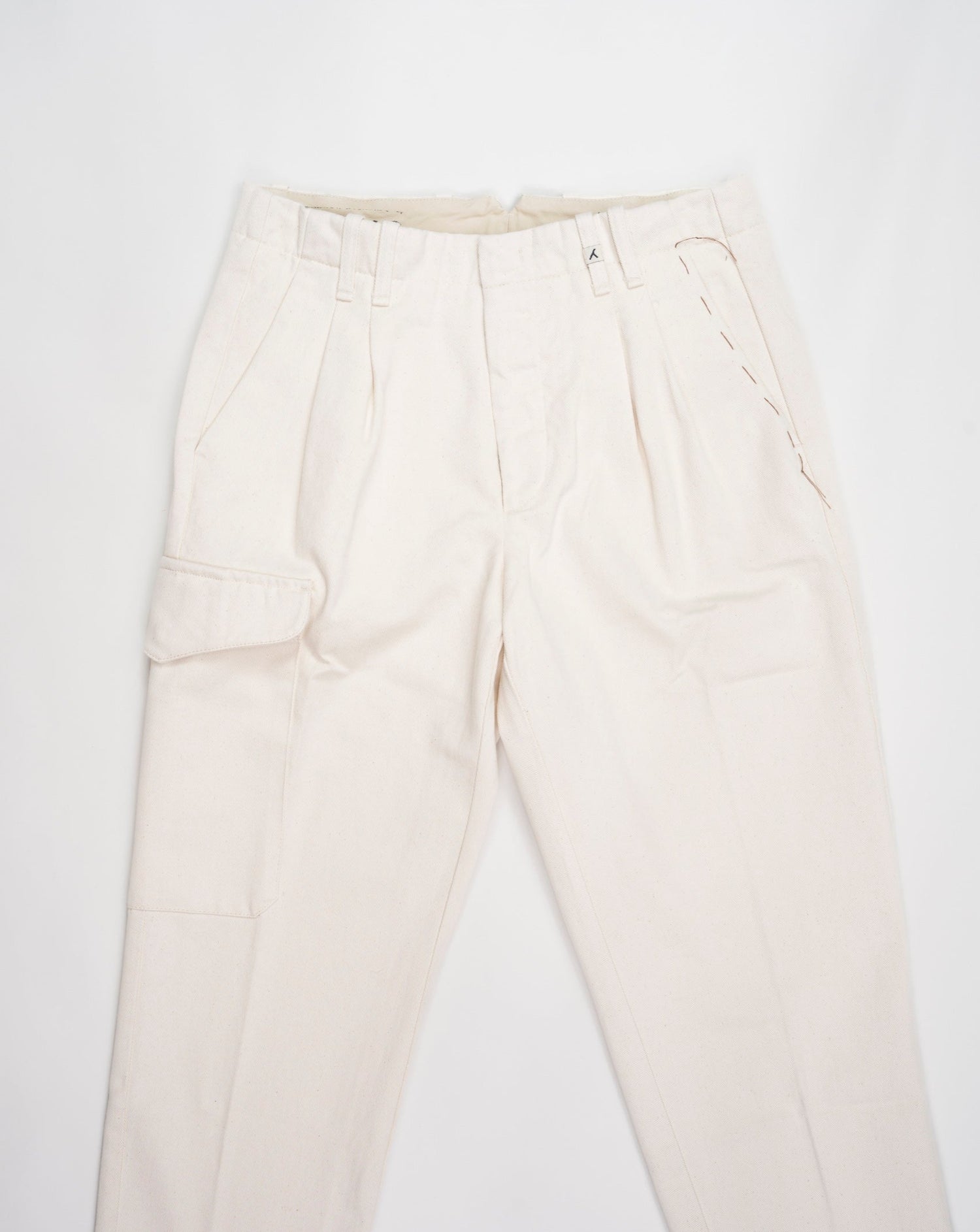 Article: 23WM45L Color: 04 / Natural White Composition: 100% Cotton  Carrot fit Ajustable hem Cargo pocket on right side Pleated front Delivered in Myths cotton bag Made in Italy Myths Pleated Cargo Trousers / Natural White