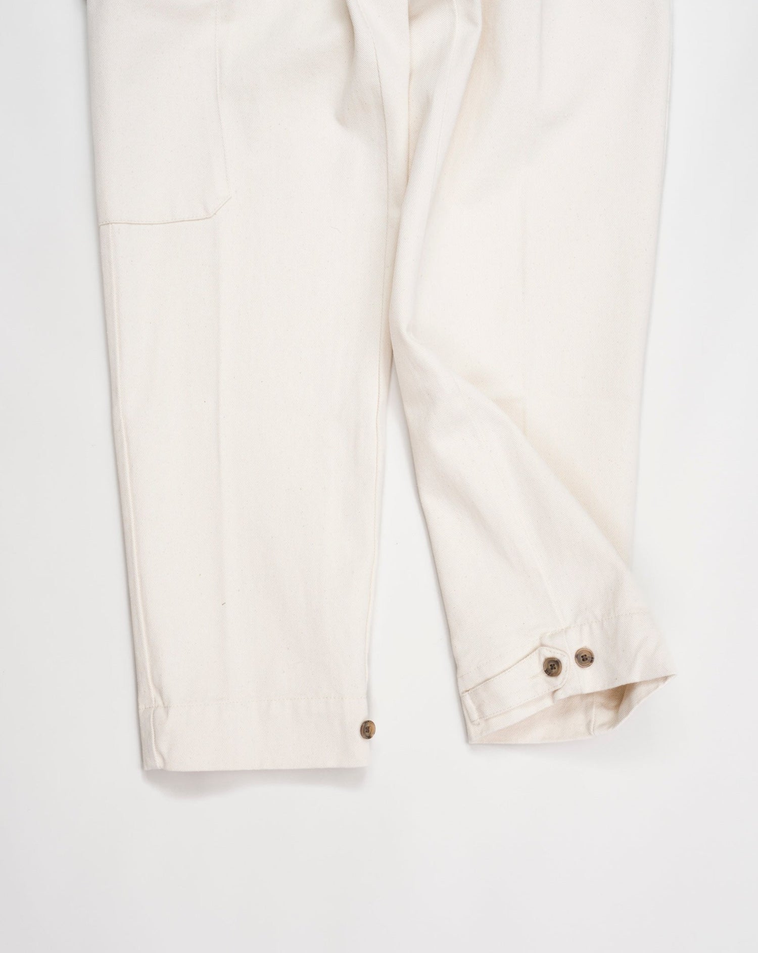 Article: 23WM45L Color: 04 / Natural White Composition: 100% Cotton  Carrot fit Ajustable hem Cargo pocket on right side Pleated front Delivered in Myths cotton bag Made in Italy Myths Pleated Cargo Trousers / Natural White