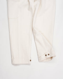 Article: 23WM45L Color: 04 / Natural White Composition: 100% Cotton  Carrot fit Ajustable hem Cargo pocket on right side Pleated front Delivered in Myths cotton bag Made in Italy Myths Pleated Cargo Trousers / Natural White