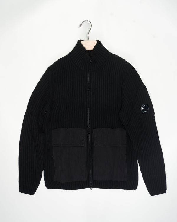 C.P. Company Lambswool Mixed Zipped Knit / Black  15CMKN226A 005504MG Col 999 Black 80% wool 20%polyamide 2 flapped nylon pockets and 2 hand warmer pockets with snap buttons 2 way zip in front